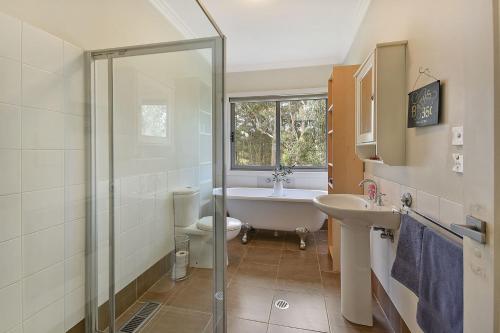 Un baño con ducha, lavabo e inodoro. en Georgette House in Leura, en Leura