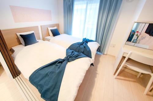 a hotel room with two beds and a desk at Tokyo Sunshine Tower Premium Hotel in Tokyo