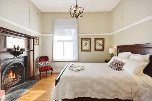 um quarto com uma cama grande e uma lareira em Kings Bower em Katoomba