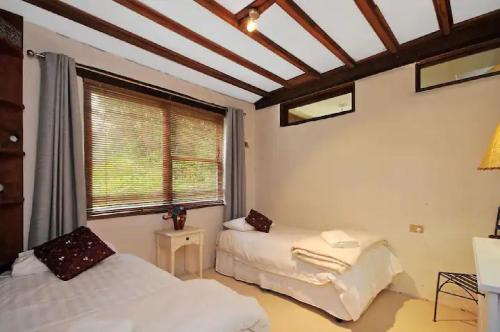 1 Schlafzimmer mit 2 Betten und einem Fenster in der Unterkunft Nagual Retreat in Leura with views in Leura