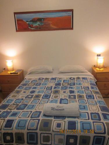 a bed in a bedroom with two lamps on dressers at Hotel Miramar in Huarmey