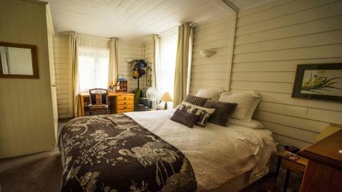 a bedroom with a large bed in a room at Rose Pine Cottage at Leura in Leura