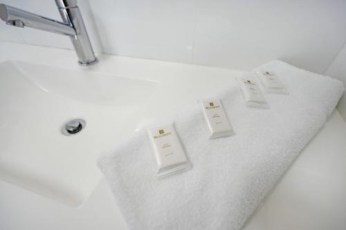 Palm Valley Motel في Tarro: حمام به منشفة بيضاء على منضدة