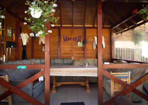 una habitación con sofá y mesa en una cabaña en Pensiunea Novac en Durau