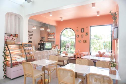 a restaurant with pink walls and tables and chairs at Ang Pao Hotel - SHA Extra Plus in Phuket Town