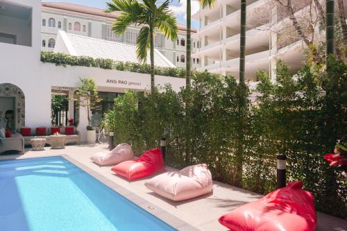 a pool with inflatable pillows next to a building at Ang Pao Hotel - SHA Extra Plus in Phuket Town