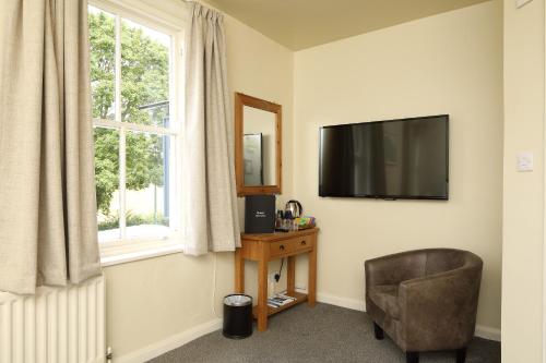 a living room with a chair and a television at The Avenue in Durham