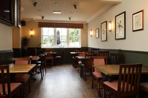 a restaurant with wooden tables and chairs and a window at The Avenue in Durham