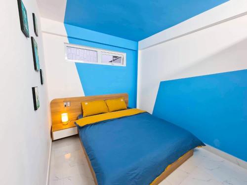 Un dormitorio azul y blanco con una cama. en EURO HOUSE en Dalat