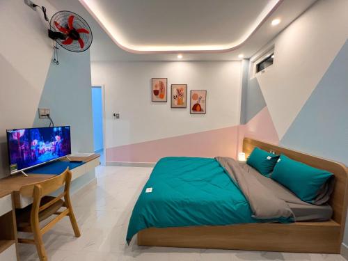 um quarto com uma cama, uma secretária e uma televisão em EURO HOUSE em Da Lat