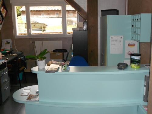 an office with a blue counter and a desk at Hotel Les Sapins in Gérardmer