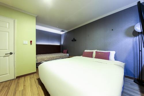 a bedroom with a large white bed in a room at Central Hotel in Changwon
