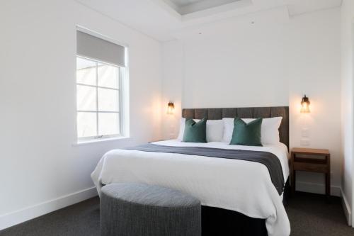 a bedroom with a large bed with green pillows at The Louise in Marananga
