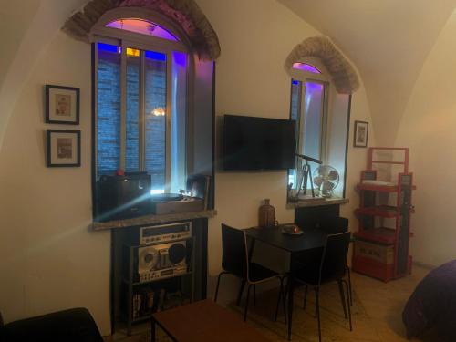 sala de estar con mesa, TV y 2 ventanas en Private Room Studio Suite Jerusalem, en Jerusalén