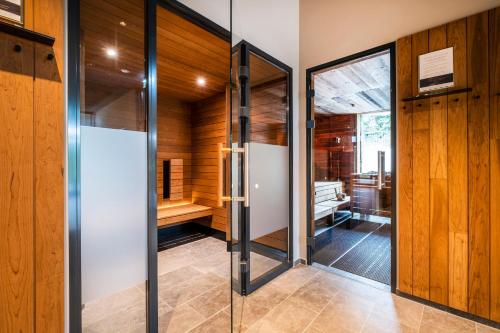 a sauna with wooden walls and glass doors at Hotel Breitenburg in Breitenburg