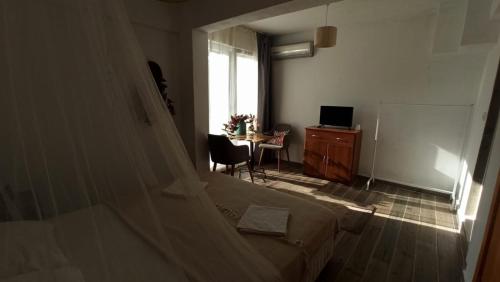 a bedroom with a bed and a table and a window at Gölyaka Hotel in Bursa
