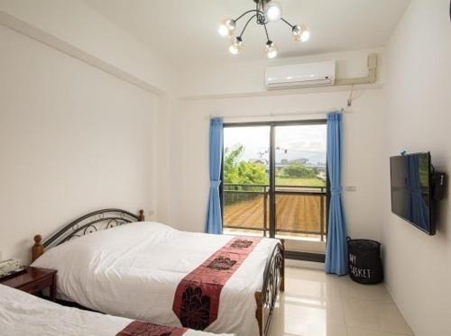 a bedroom with two beds and a window at Chang Hiong Homestay in Yilan City