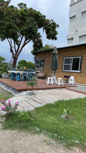 a house with a patio with an umbrella and chairs at Haibian Mingren 50 in Hualien City