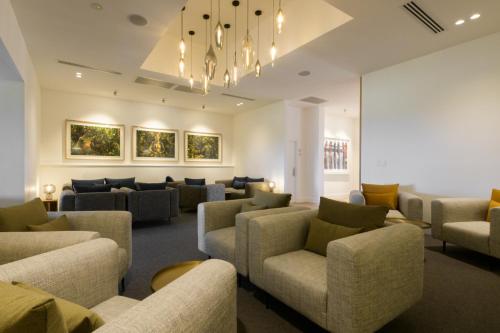 a waiting room with couches and chairs and a chandelier at The Louise in Marananga