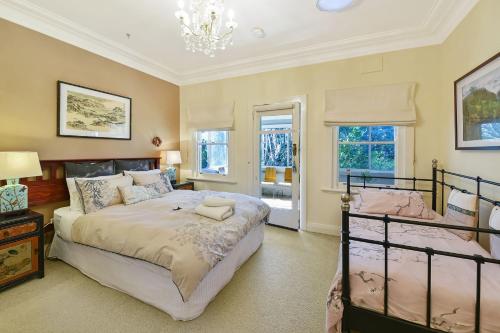 Un dormitorio con dos camas y una lámpara de araña. en Woodford House of Leura, en Leura