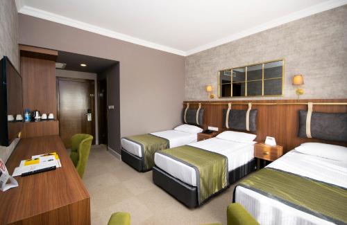 a hotel room with two beds and a table at CONNECT THERMAL HOTEL in Ankara