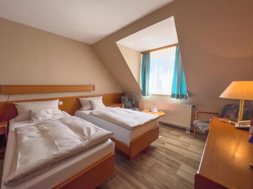 a hotel room with two beds and a window at Hotel Landhaus Wörlitzer Hof in Oranienbaum-Wörlitz