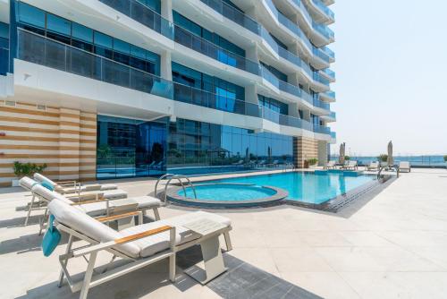 a swimming pool in front of a building at GlobalStay Business Bay Waves Tower Apartments Dubai in Dubai