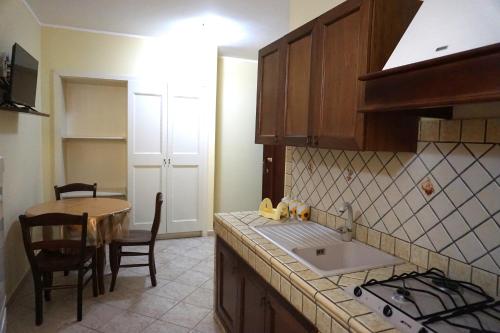 a kitchen with a sink and a table and a counter at Puesta De Sol Residence in Lampedusa