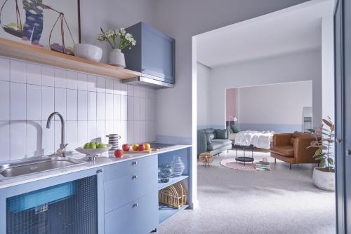 a kitchen with a sink and a living room at M Village Living Lý Chính Thắng in Ho Chi Minh City
