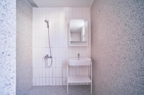 a white bathroom with a sink and a shower at M Village Living Lý Chính Thắng in Ho Chi Minh City