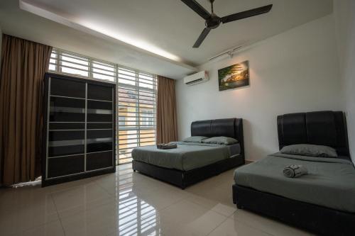 1 dormitorio con 2 camas y ventana en Jack Guest House KB 5 Rooms 4 Toilets - Max 20 pax en Kota Bharu