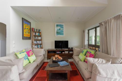 a living room with two couches and a coffee table at Muri Beach Villa in Rarotonga