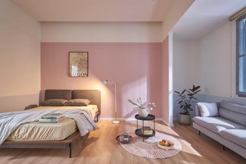 a bedroom with a bed and a couch and a table at M Village Living Lý Chính Thắng in Ho Chi Minh City