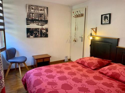 シルティカイムにあるAu Merlenchanteurのベッドルーム(赤いベッド1台、椅子付)
