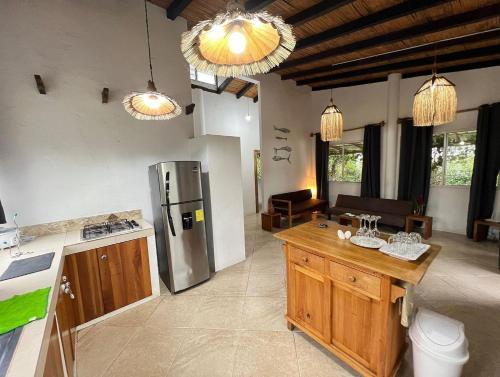 a kitchen with a refrigerator and a table at Olon Cabin in Olón