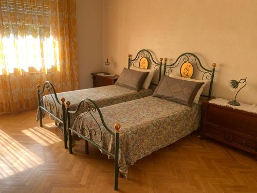 sypialnia z 2 łóżkami i drewnianą podłogą w obiekcie Il Salottino di San Paolo w Rzymie