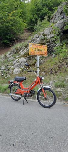 una moto rossa parcheggiata sul ciglio di una strada di Holiday bungalows Pajkovir a Kolašin
