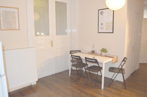 Artist Guest House في بودابست: غرفة مع طاولة وكراسي في غرفة