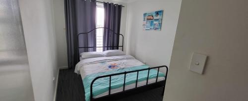 a small bed in a room with a window at North Coogee Beach House in Fremantle