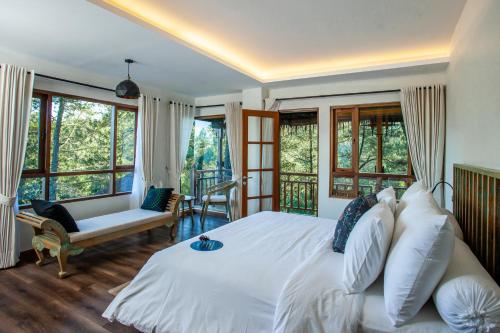 Tira Vilagna Suites & Spa في Kintamani: غرفة نوم بسرير ابيض كبير ونوافذ