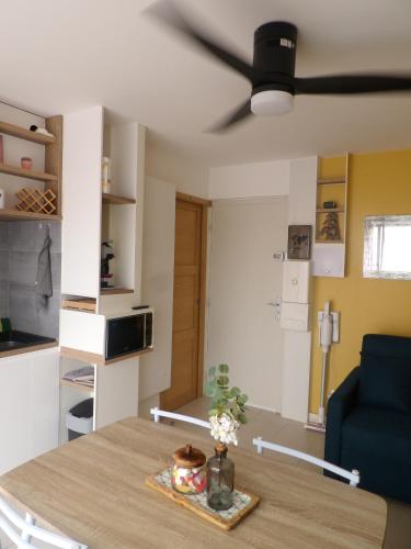 - un salon avec une table et un ventilateur de plafond dans l'établissement Cosy studio au bord de la plage, à Gruissan