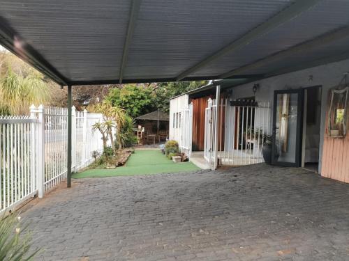 un patio de una casa con una valla blanca en SomethingElz@Grace, en Pretoria