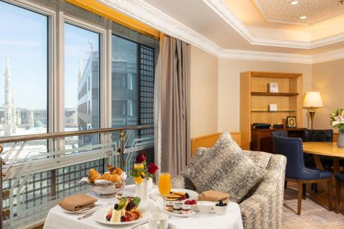 ein Hotelzimmer mit einem Tisch mit Essen und einem großen Fenster in der Unterkunft MADEN Hotel in Medina