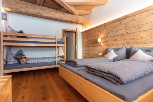 2 Etagenbetten in einem Schlafzimmer mit Holzwänden in der Unterkunft Moarhof in Unken