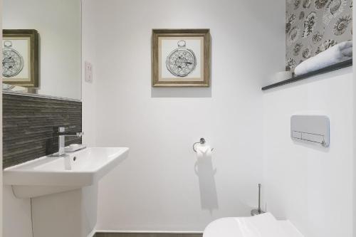 Un baño blanco con lavabo e inodoro. en The Oyster, en St Ives