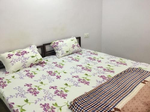 łóżko z fioletowymi kwiatami i dwoma poduszkami w obiekcie HOTEL SWAGAT w mieście Bokāro