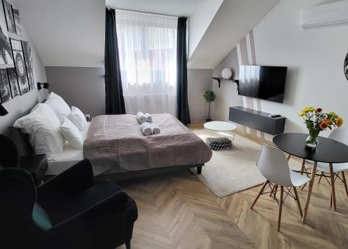 um quarto com uma cama, uma mesa e cadeiras em Dotis Apartman Tata em Tata