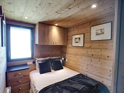 a bedroom in a log cabin with a bed in it at Appartement Les Menuires, 3 pièces, 6 personnes - FR-1-178-68 in Les Menuires