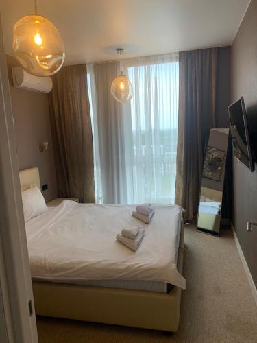 a bedroom with a bed and a large window at Nyvky Like Home - Fayna Town - apt 398 in Kyiv