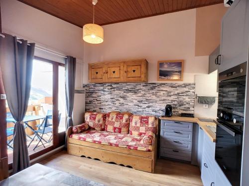 un salon avec un canapé dans une cuisine dans l'établissement Studio cabine rénové 4 pers 24m², au pied des pistes, Les Menuires - FR-1-178-183, aux Menuires